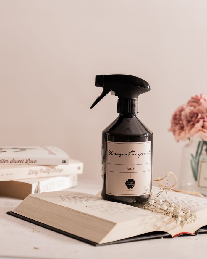 A stylish arrangement of a fragrance bottle, books, and flowers in a serene setting.