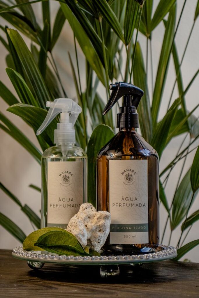 Two elegant perfume bottles displayed with natural elements and green foliage backdrop.