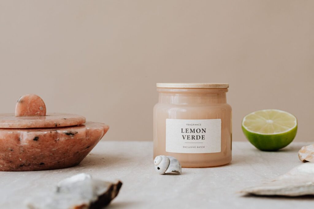 A fragrant candle surrounded by lime and natural stones on a neutral background.