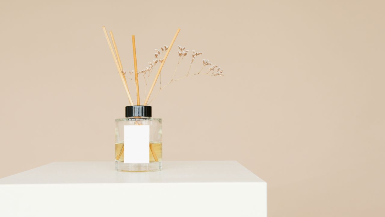 Mastering the First Impression: Your intriguing post title goes here A minimalist reed diffuser with a mockup label on a white pedestal against a neutral background.