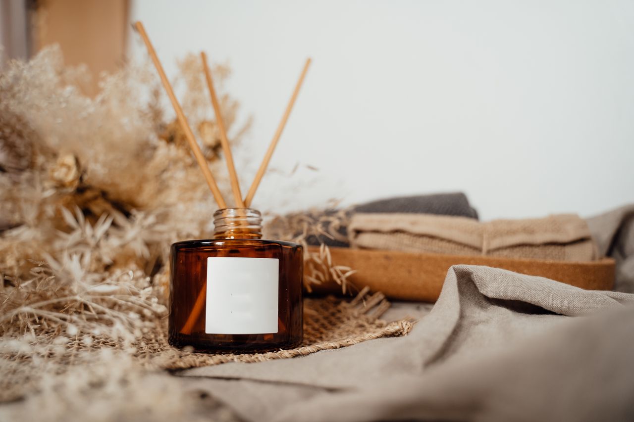 Crafting Captivating Headlines: Your awesome post title goes here Cozy home display featuring an amber glass diffuser with incense sticks, exuding tranquility.